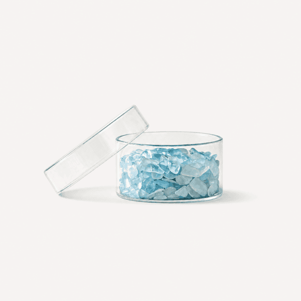 Blue-green fluorite chips in a clear container with lid on white background.