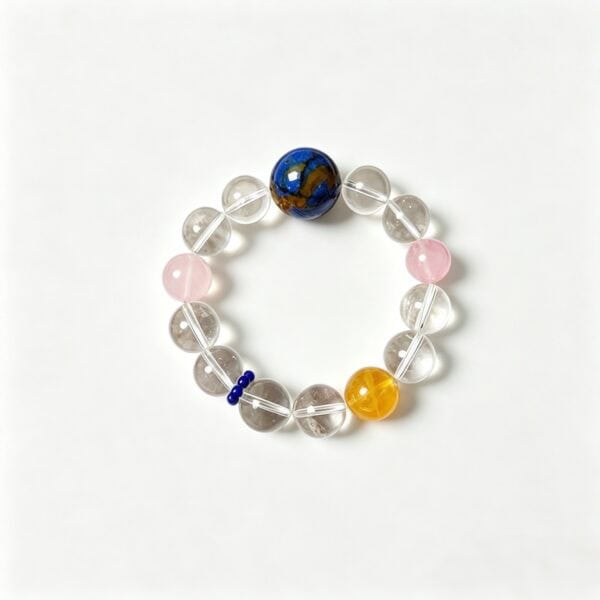 Handcrafted bracelet with clear quartz, pink, blue, and yellow beads for spiritual healing.