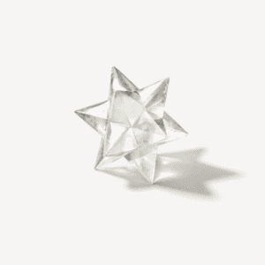 Clear crystal star ornament on white background for abundance and energy.