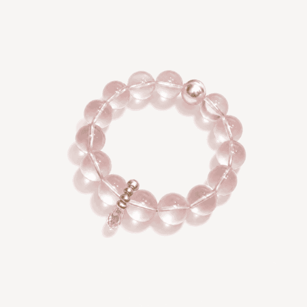 Pink rose quartz beaded bracelet with silver accents on white background.