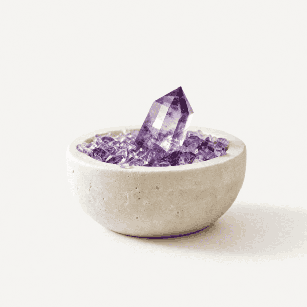 Amethyst crystal with purple stones in a white bowl for healing and growth.
