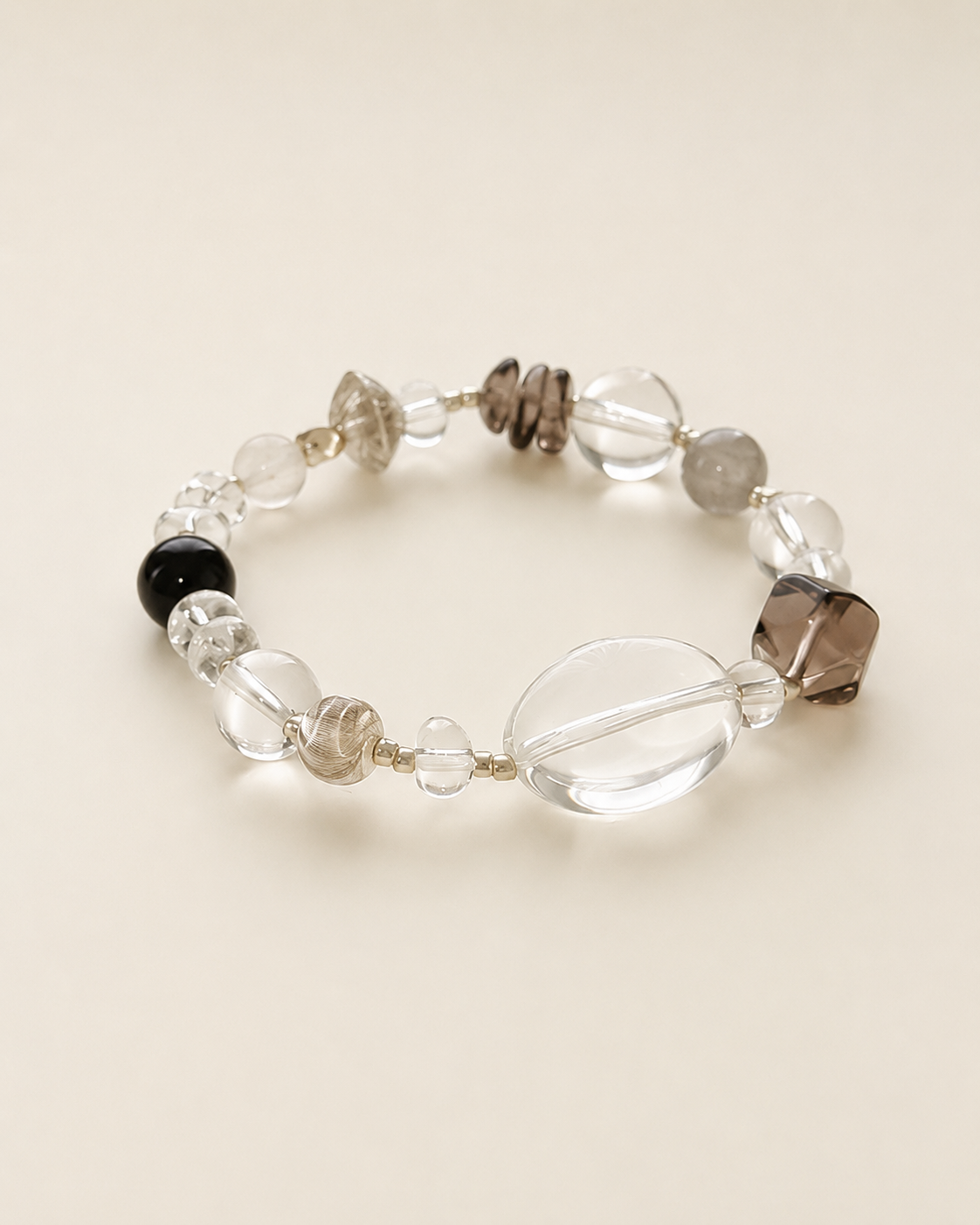 Clear and smoky crystal bracelet on a warm neutral background