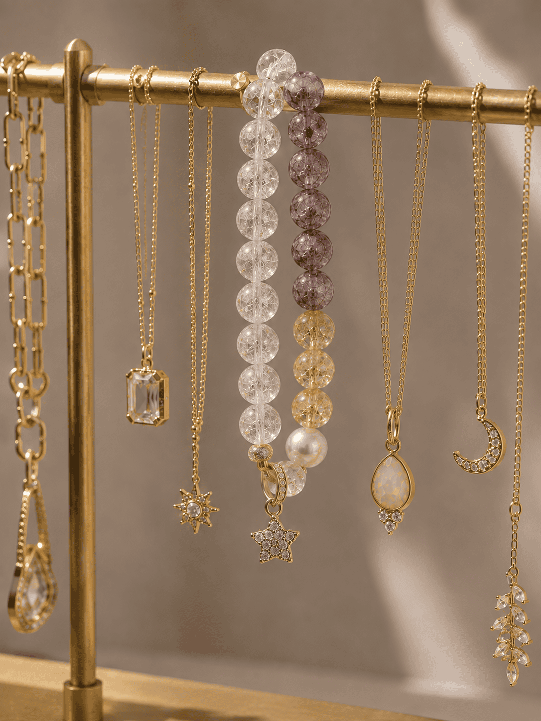 Crystal charm jewelry styled on a gold display